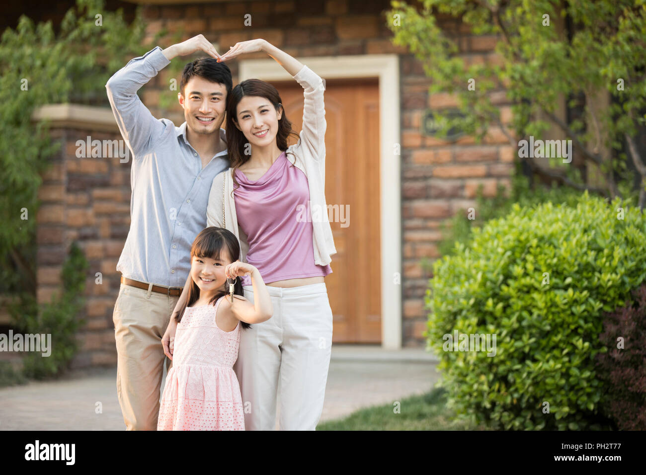 Happy young family holding keys to new house Stock Photo - Alamy