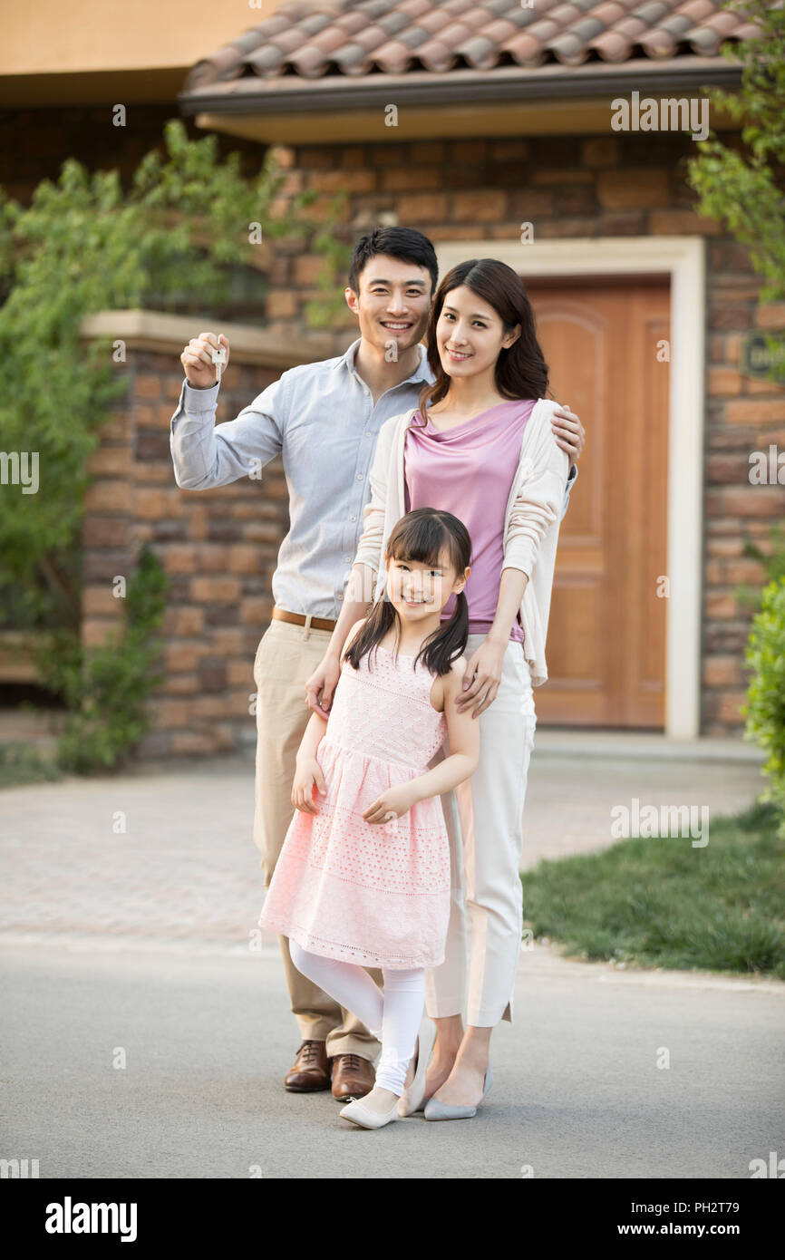 Happy young family holding keys to new house Stock Photo - Alamy