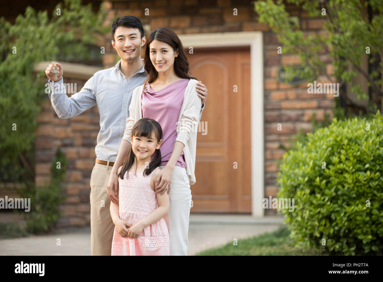 Happy young family holding keys to new house Stock Photo - Alamy
