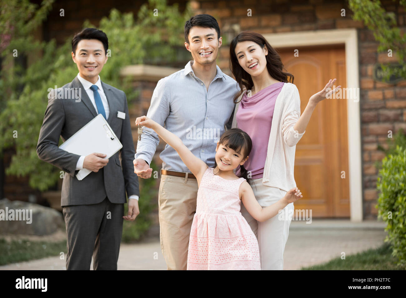 Happy young family holding keys to new house Stock Photo - Alamy