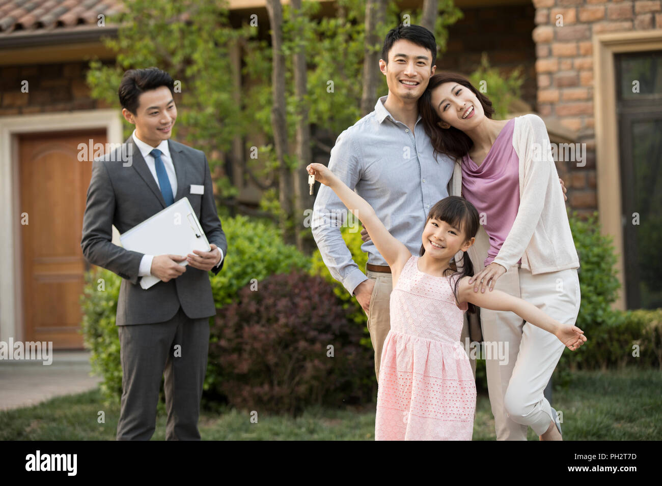 Happy young family holding keys to new house Stock Photo - Alamy