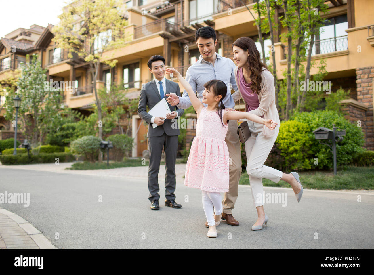 Happy young family holding keys to new house Stock Photo - Alamy