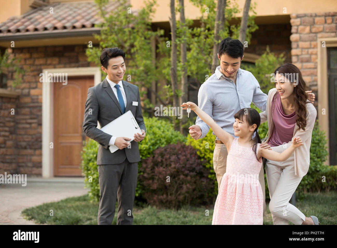 Happy young family holding keys to new house Stock Photo - Alamy