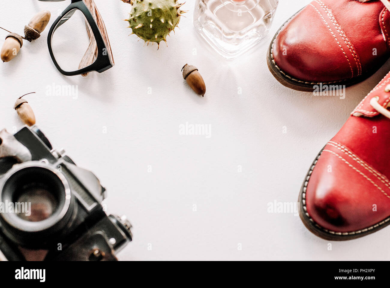 red boots lie with the camera, glasses and acorns. Stock Photo