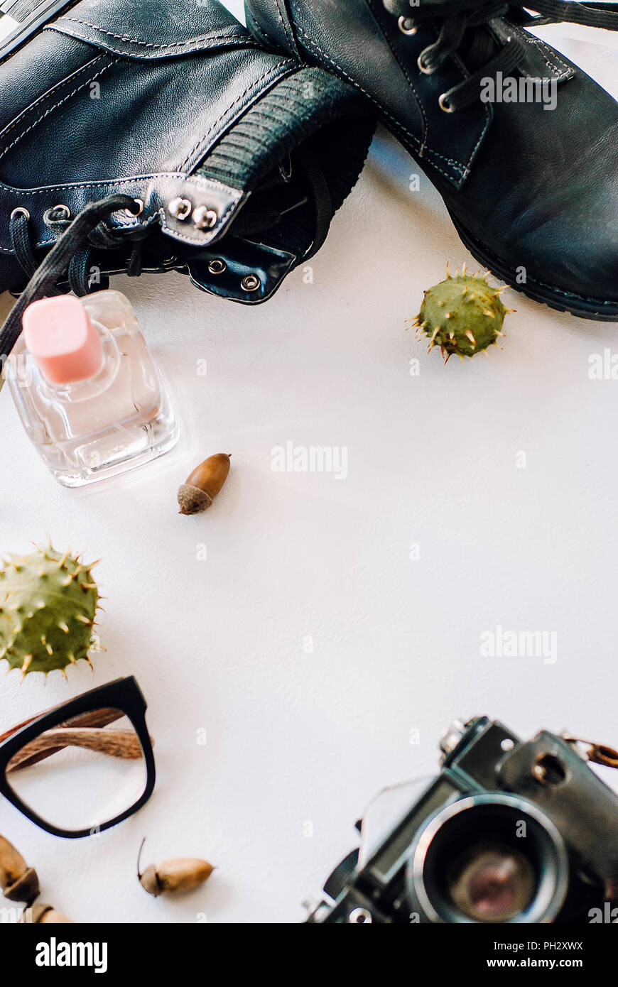 black boots lie with the camera, glasses and acorns. Stock Photo