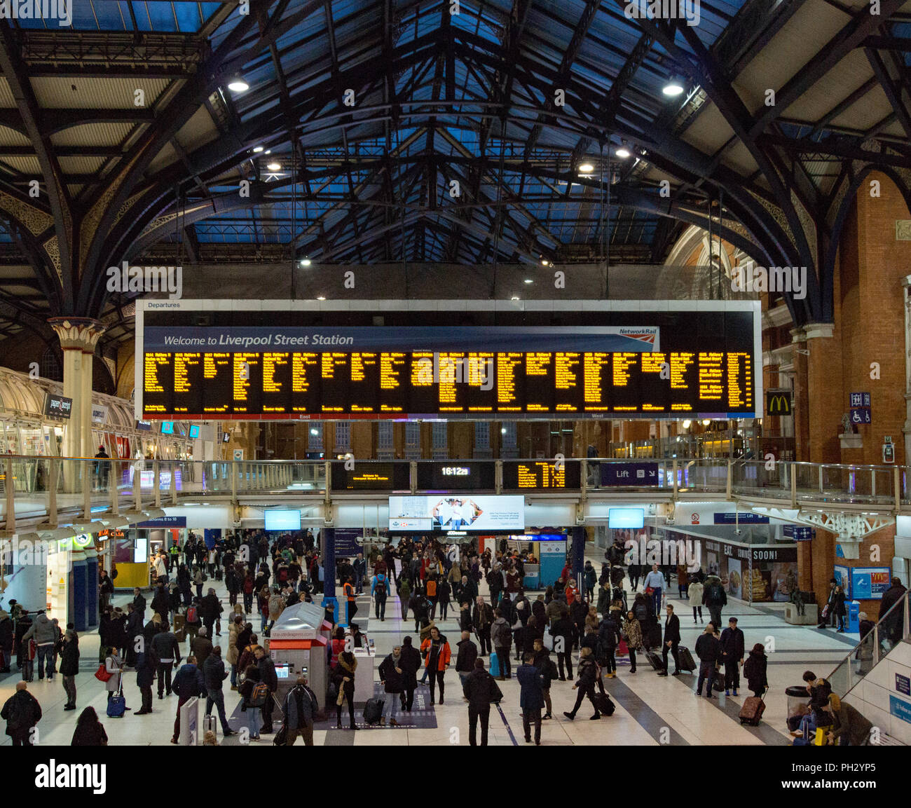 Liverpool Street rail station in London just at start of the evening rush.  The concourse in front of departure board is becoming crowded. Stock Photo