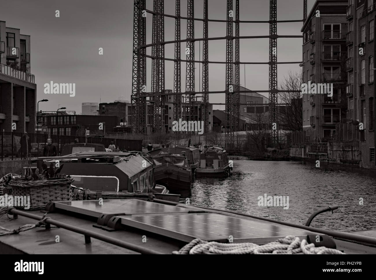Canal Boats double moored at Haggerston on the Regents canal not far from Bethnal green. Under the shadow of the empty Gas holder. Stock Photo