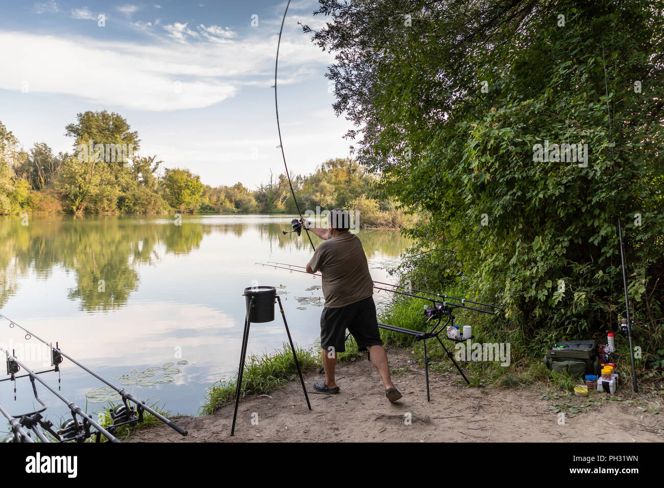 Fisherman on a lake in carp fishing action Stock Photo