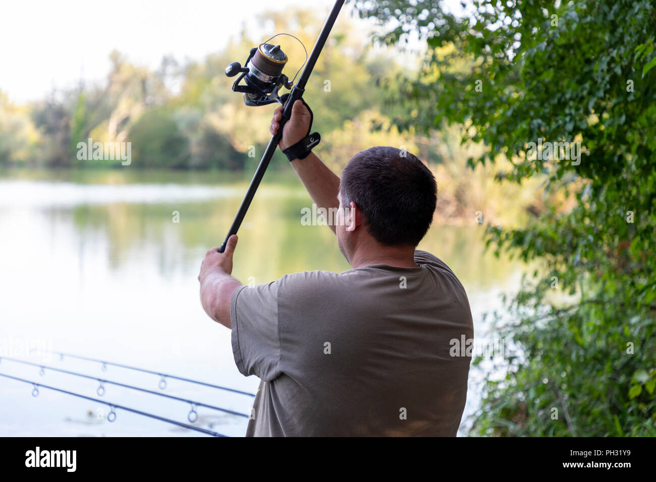 Fisherman on a lake in carp fishing action Stock Photo