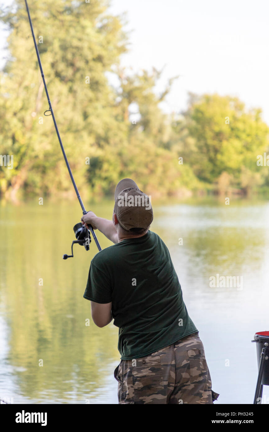 Fisherman on a lake in carp fishing action Stock Photo - Alamy