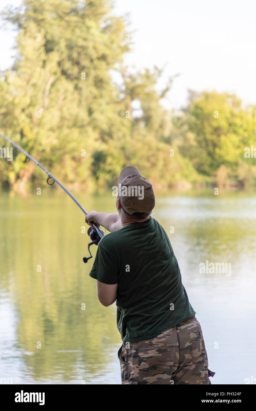 Fisherman on a lake in carp fishing action Stock Photo