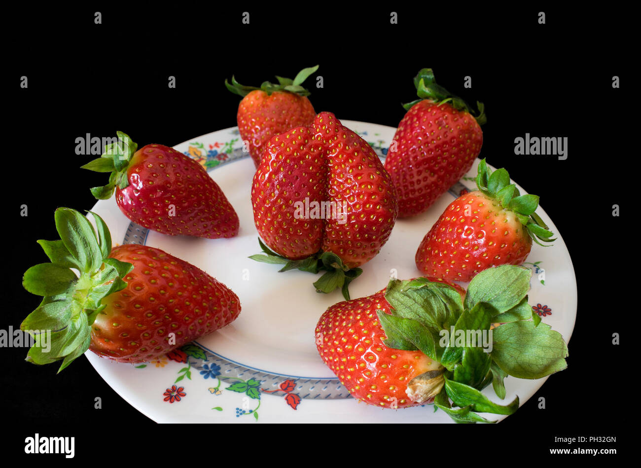 delicious strawberries on a plate with black background Stock Photo - Alamy