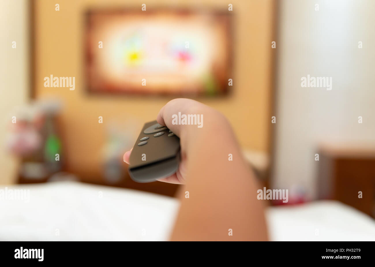 Kid Operating A Tv Remote Control In A Hotel Room Stock