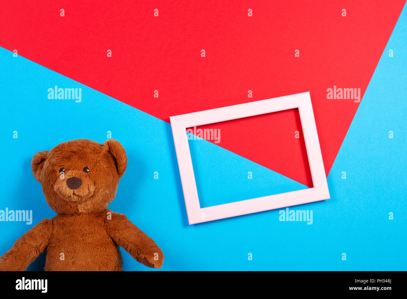 Teddy bear and white empty frame on colorful background Stock Photo
