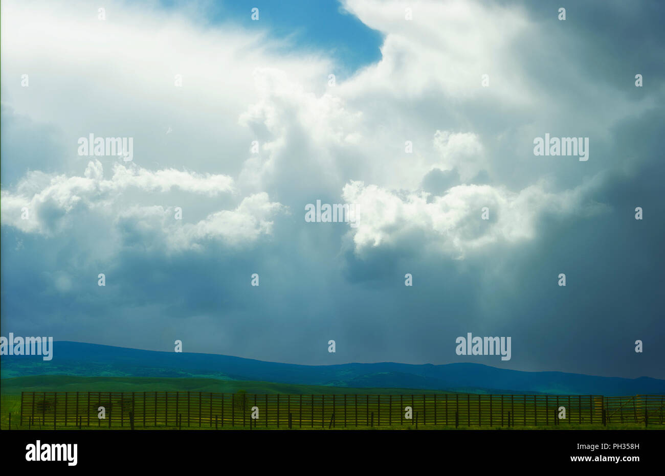 Views of Wyoming's ominous cloudy skies over open fields and sections of the Laramie Mountain Range, seen from highway 80 Stock Photo