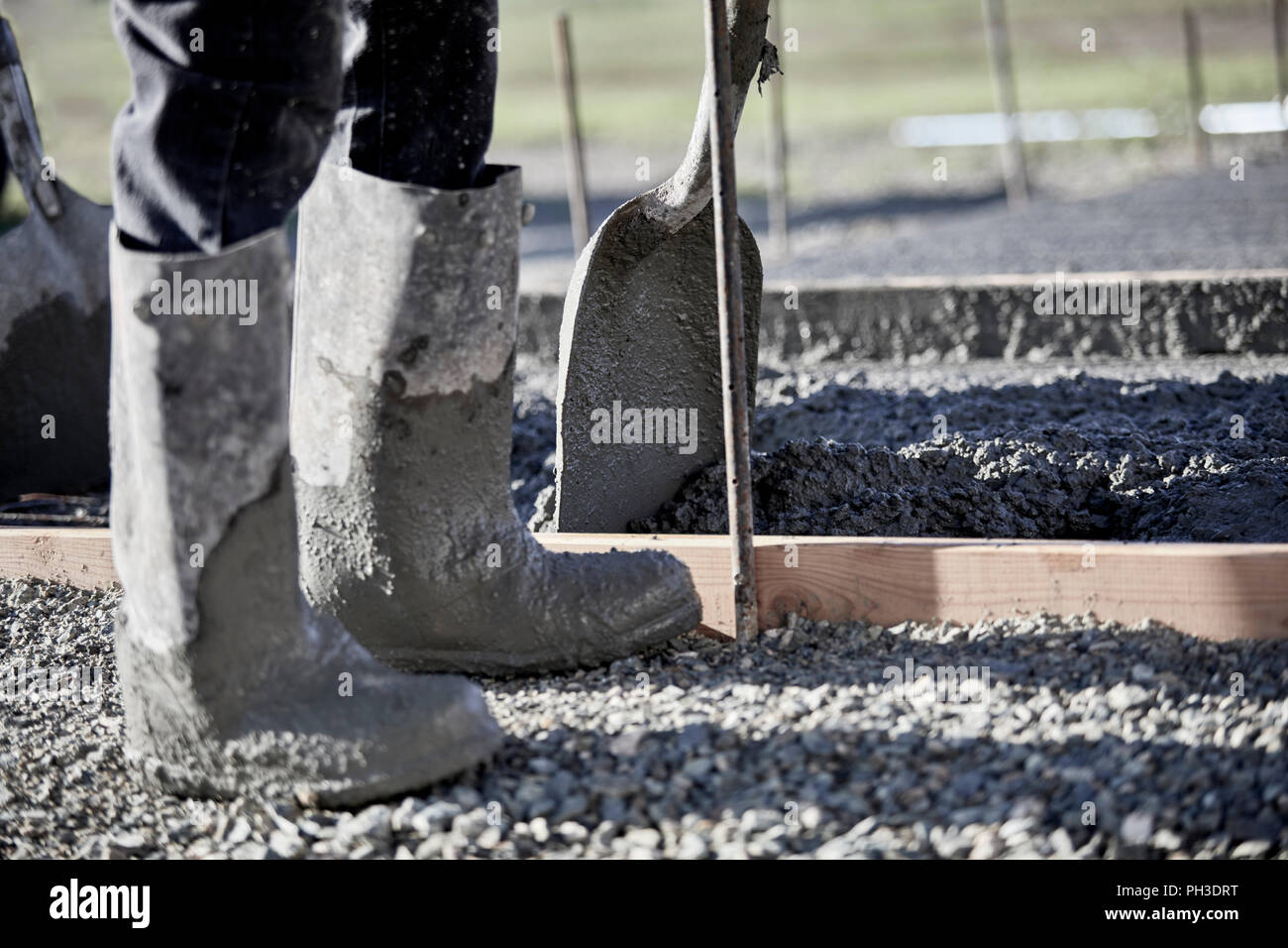 The boots of a mason working in cement with shallow depth of field Stock  Photo - Alamy