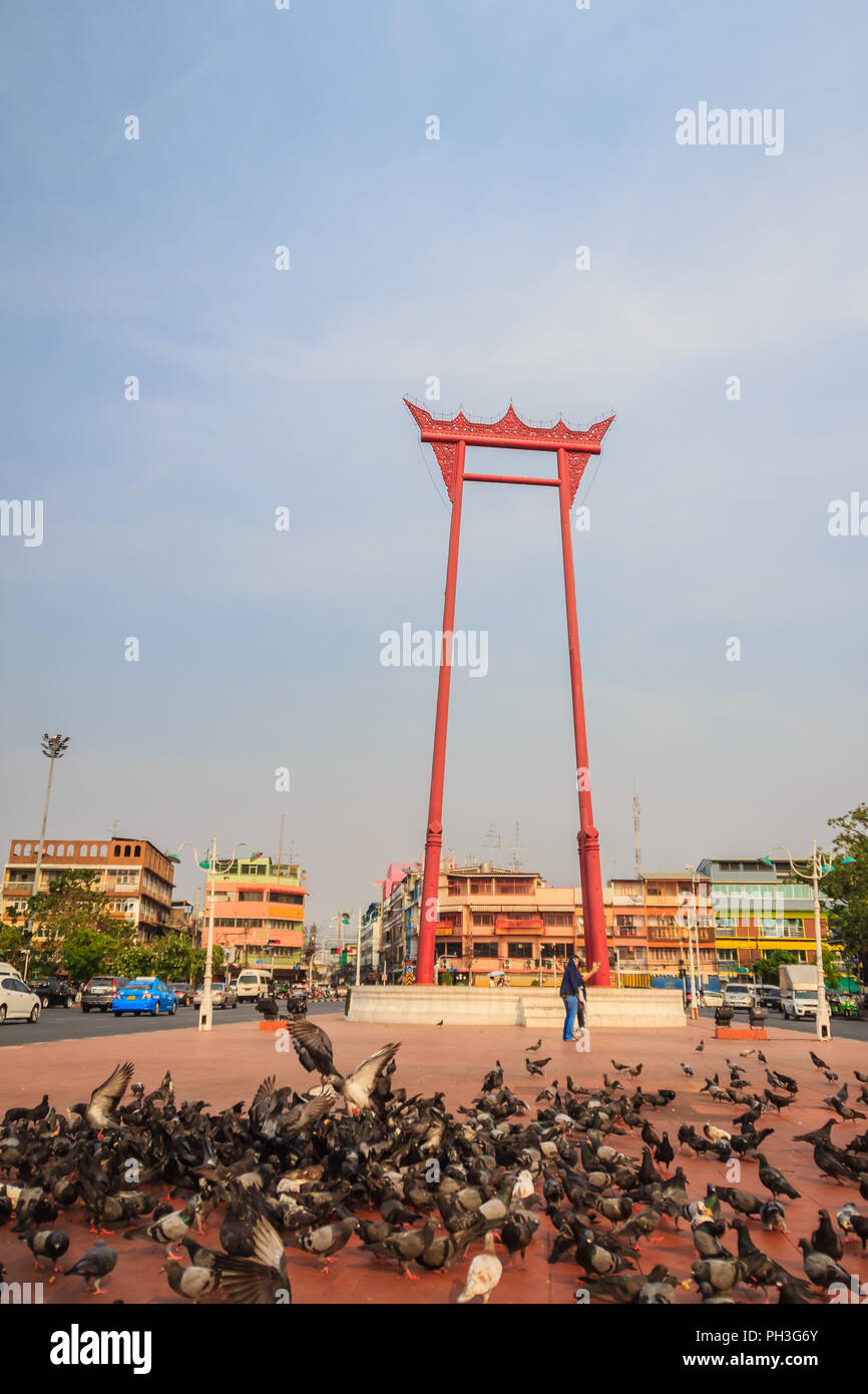 Red giant swing or Sao Ching Cha with the crowd of pigeon, one of the most famous tourist attraction and landmark in Bangkok, Thailand. Stock Photo