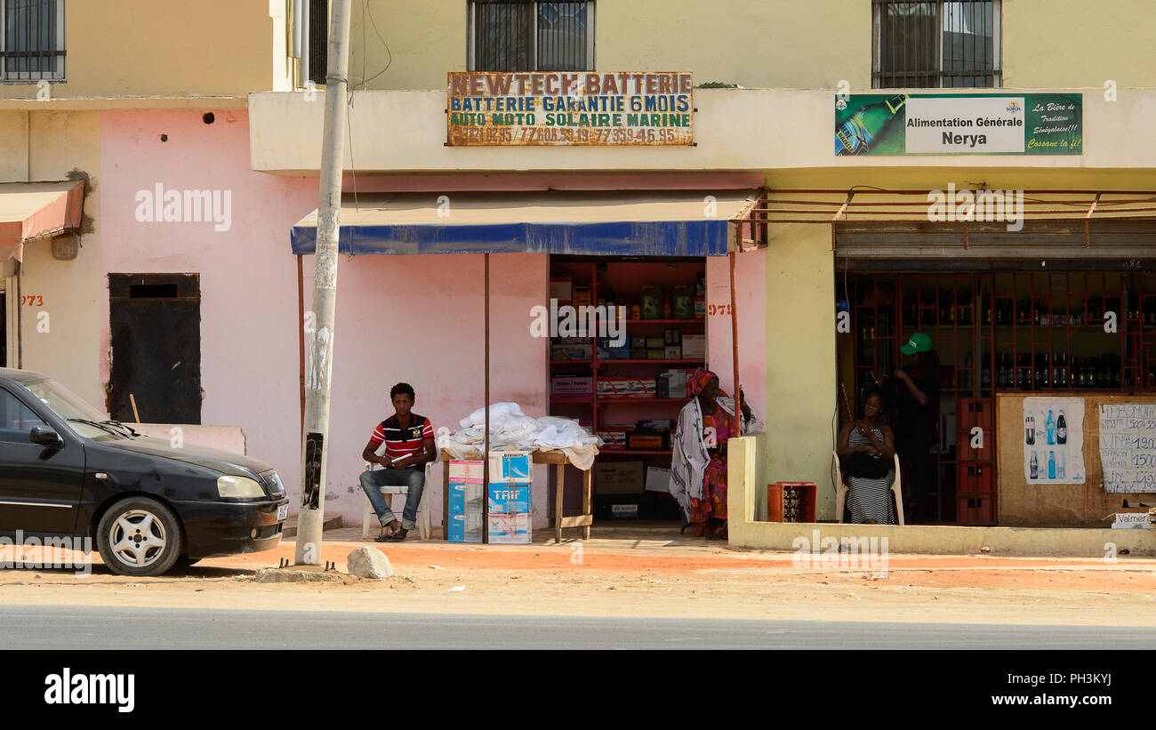 DAKAR, SENEGAL - APR 27, 2017: Unidentified Senegalese woman in traditional clothes stands near the shop in Dakar, the capital of Senegal Stock Photo