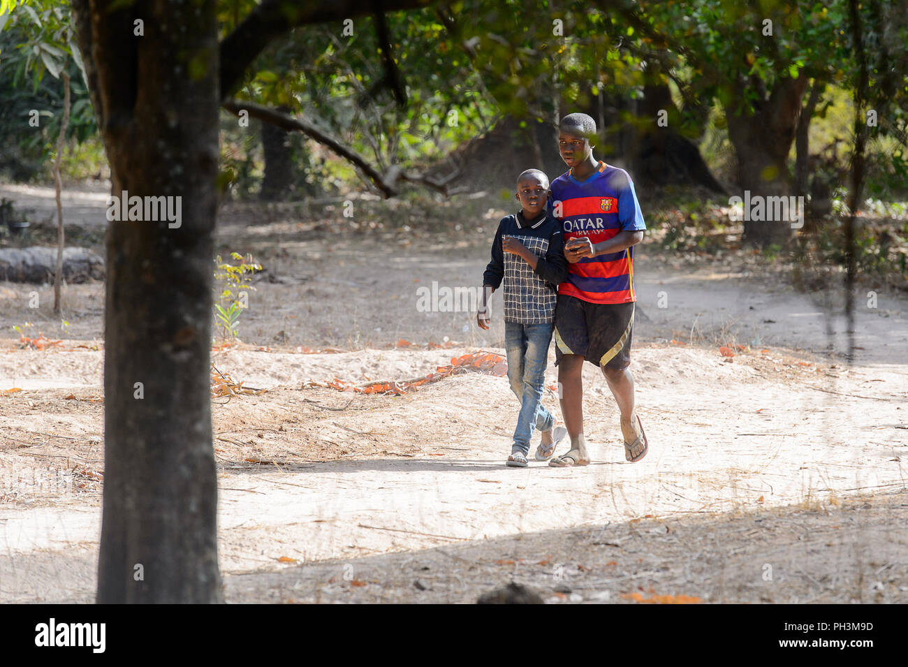 OUSSOUYE, SENEGAL - APR 30, 2017: Unidentified Senegalese  two boys walk in the Sacred Forest near Kaguit village Stock Photo