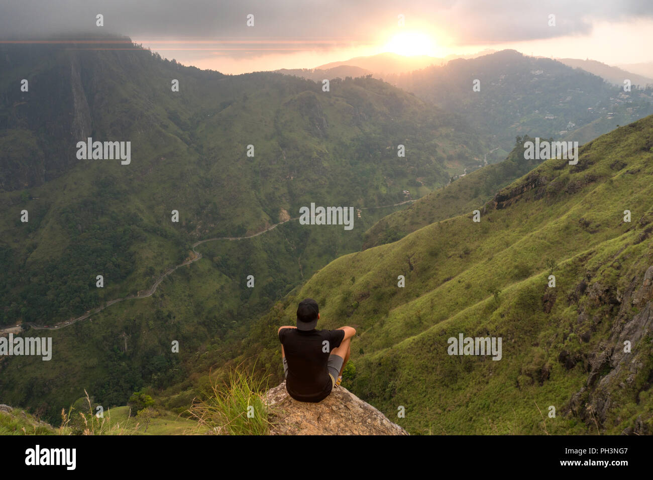 Man sitting on rock watching sunset hi-res stock photography and images ...