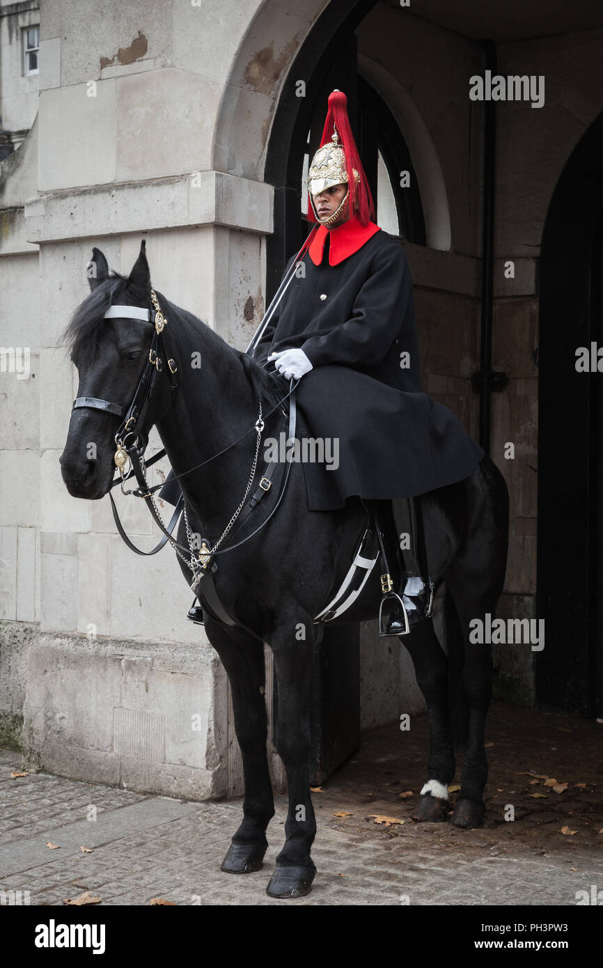 London, United Kingdom - October 29, 2017: Trooper of the Household Cavalry on black horse stands near Horse Guards of Whitehall in central London Stock Photo