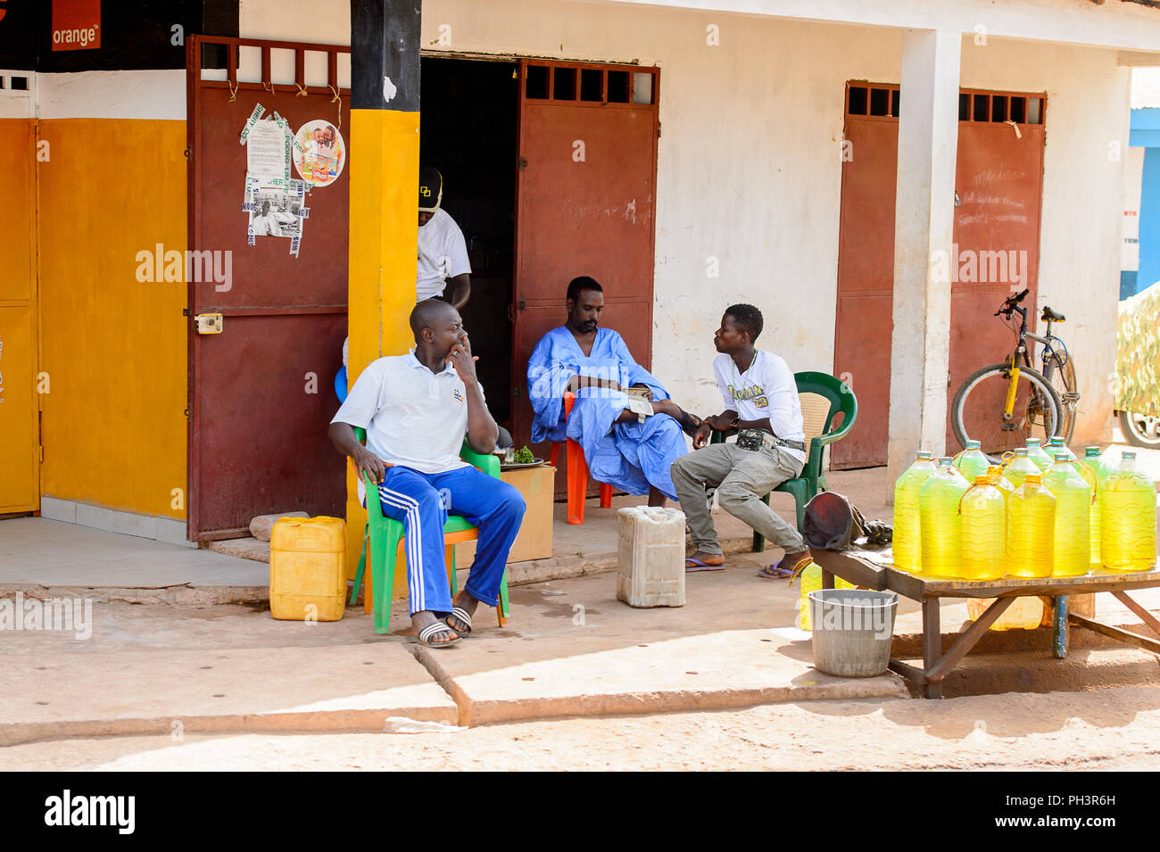 ROAD TO BISSAU, GUINEA B. - MAY 1, 2017: Unidentified local men talk about something in a village in Guinea Bissau. Still many people in the country l Stock Photo