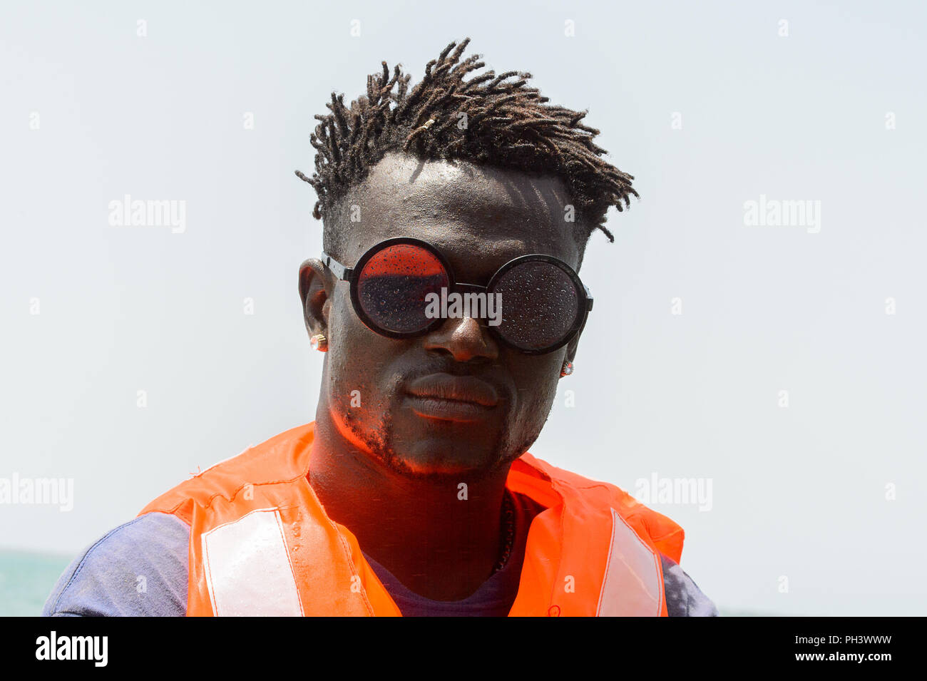 ORANGO ISLAND, GUINEA BISSAU - MAY 3, 2017: Unidentified local man in  orange vest wears sunglasses and sails in a boat on the Orango Island,  Guinea Bi Stock Photo - Alamy
