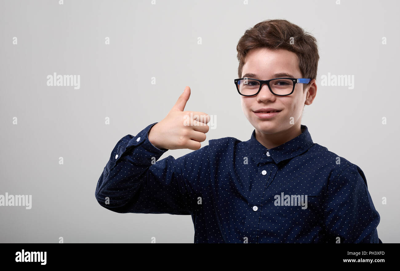 Schoolboy with glasses in closeup, showing thumbs up Stock Photo - Alamy