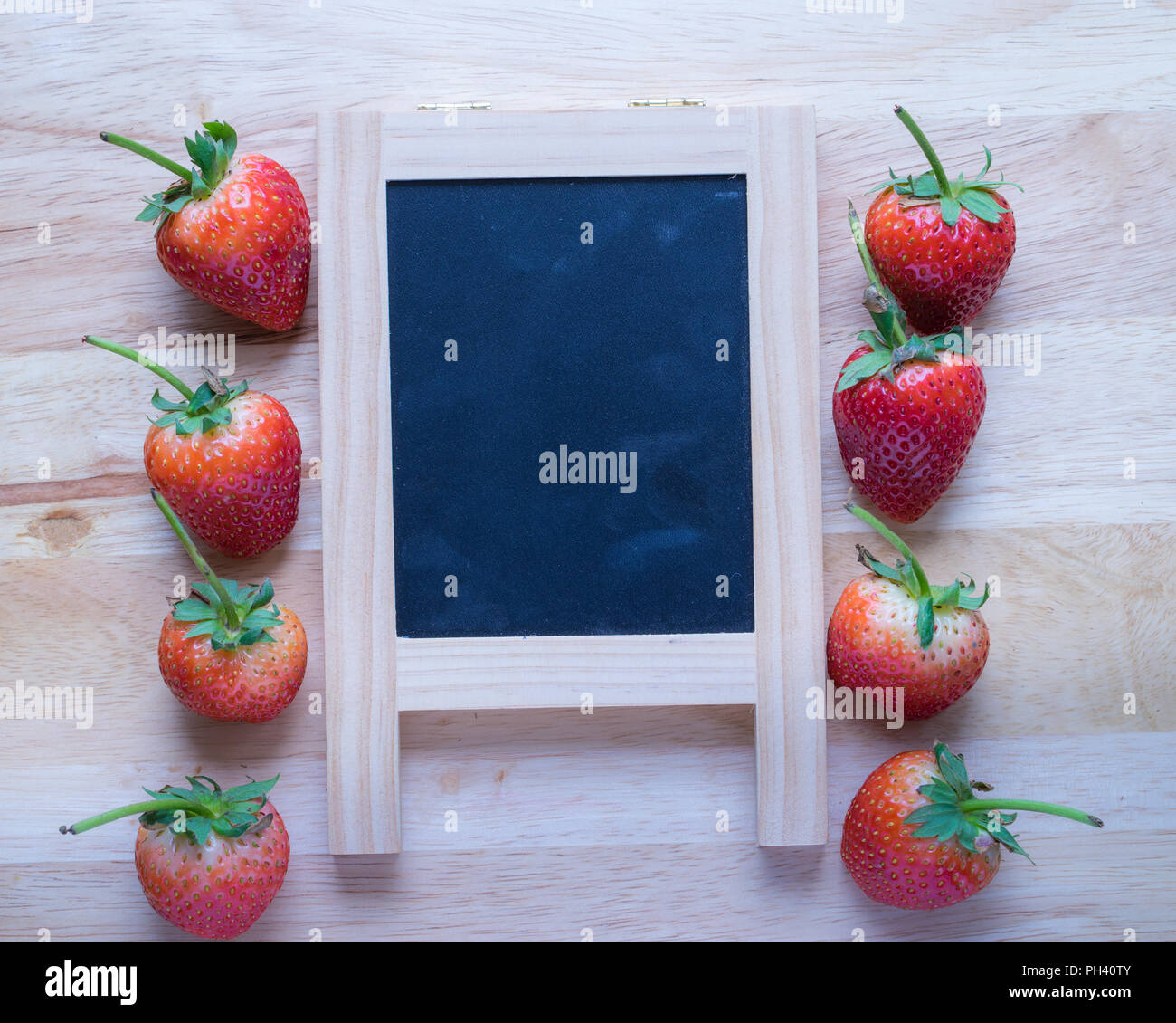 Strawberry and black board on wooden pattern background, Stock Photo