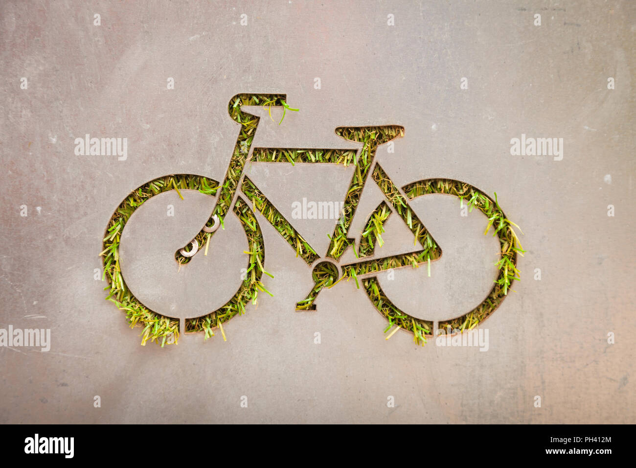 Symbolic bicycle cut out of metal with grass growing UK Stock Photo