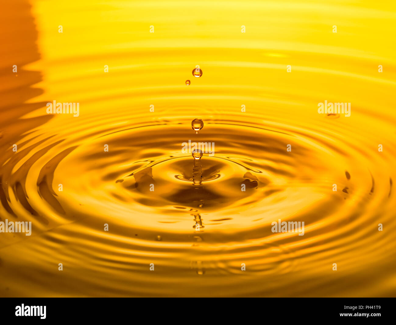 close up of a drop oil on a yellow background Stock Photo - Alamy