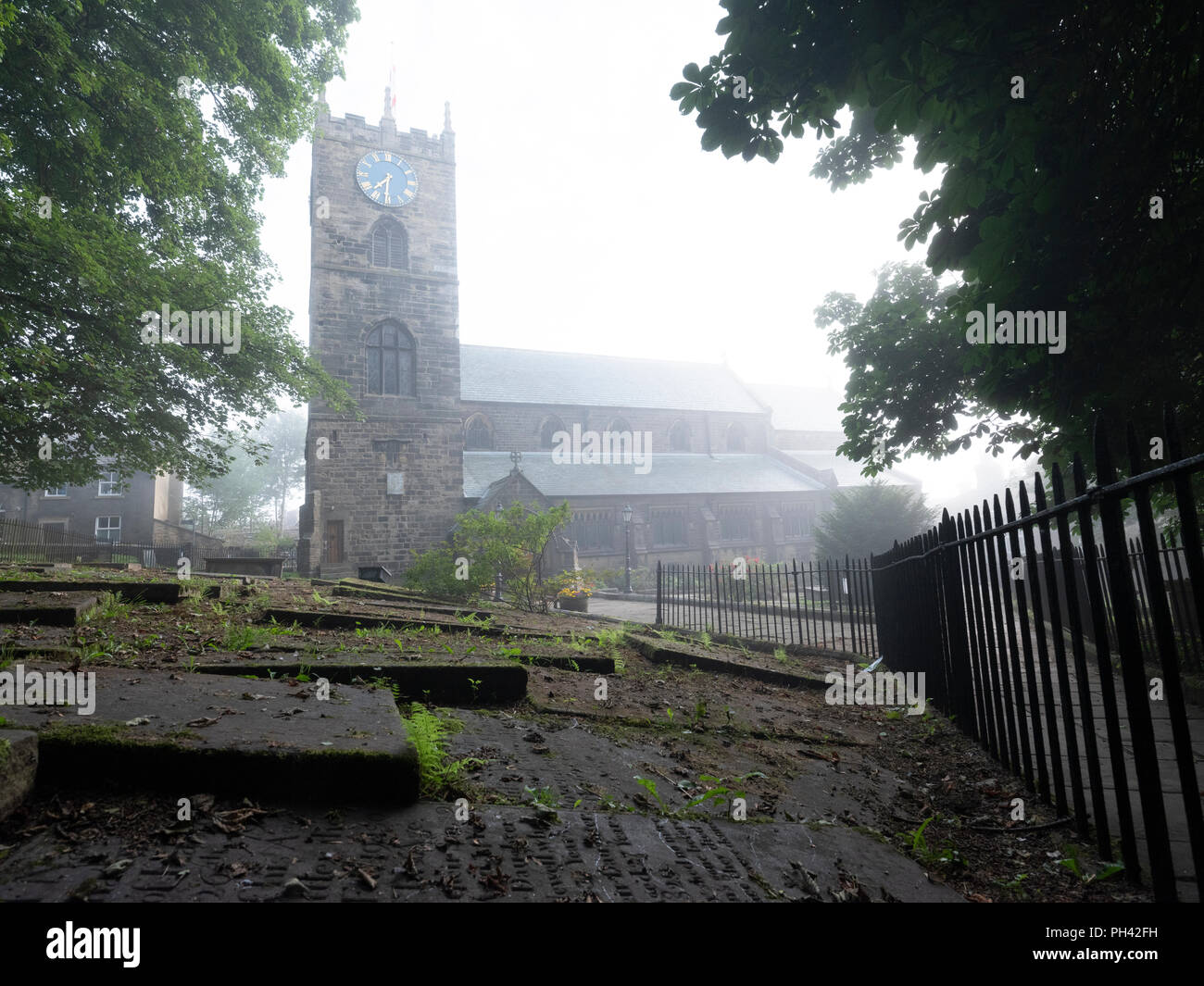 Haworth Church and graveyard, in West Yorkshire, home of the Bronté family, in early morning mist, no people Stock Photo