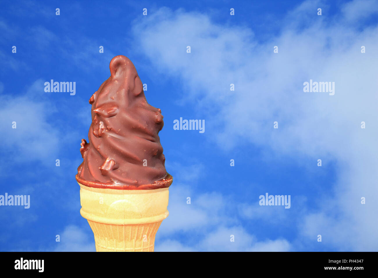 Chocolate Dipped Soft Serve Ice Cream Cone Against Vivid Blue Sky with