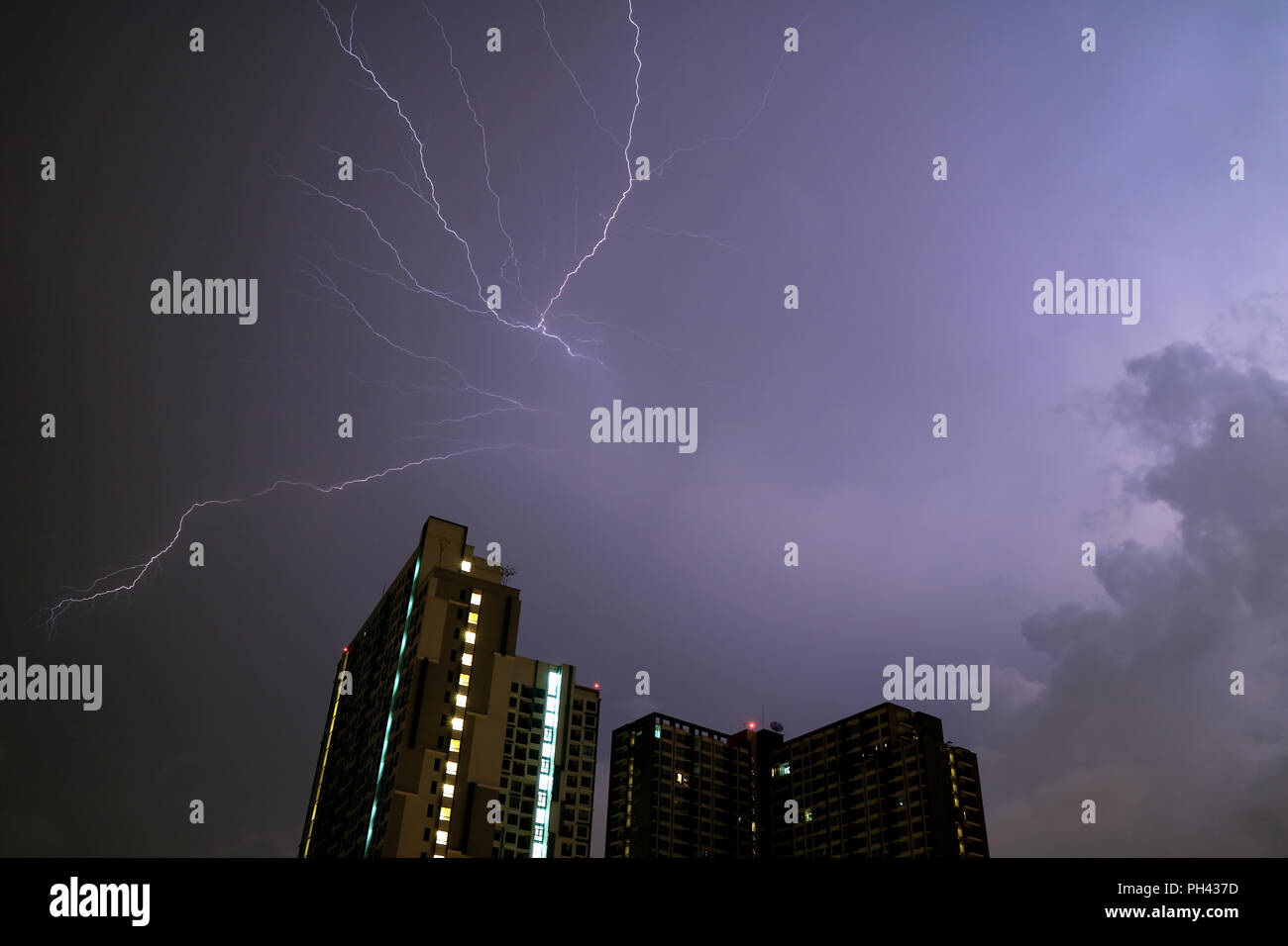 Awesome View of Real Lightning Striking on Night Sky over the High Building Stock Photo