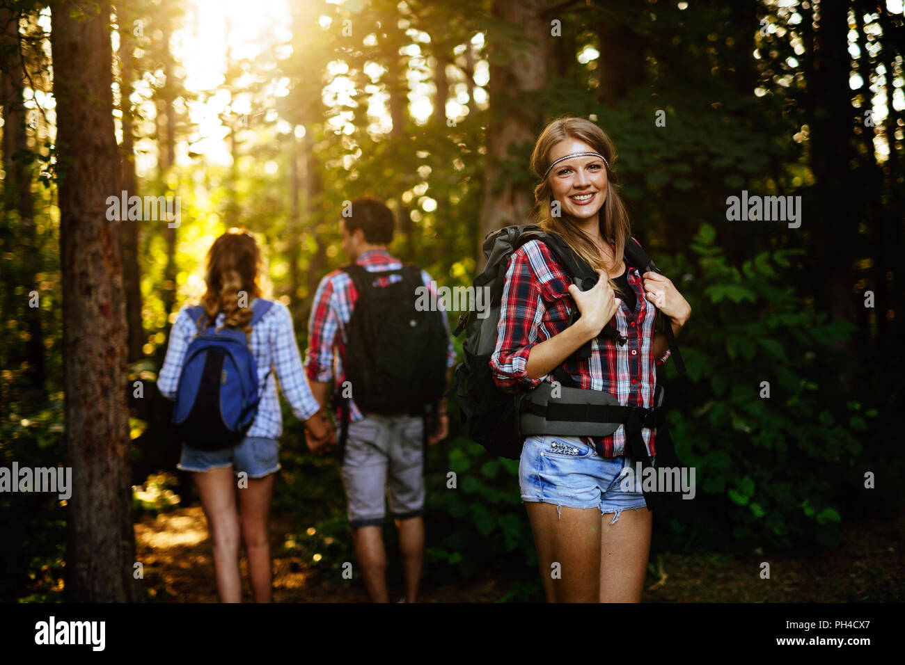Beautiful woman and friends hiking in forest Stock Photo - Alamy
