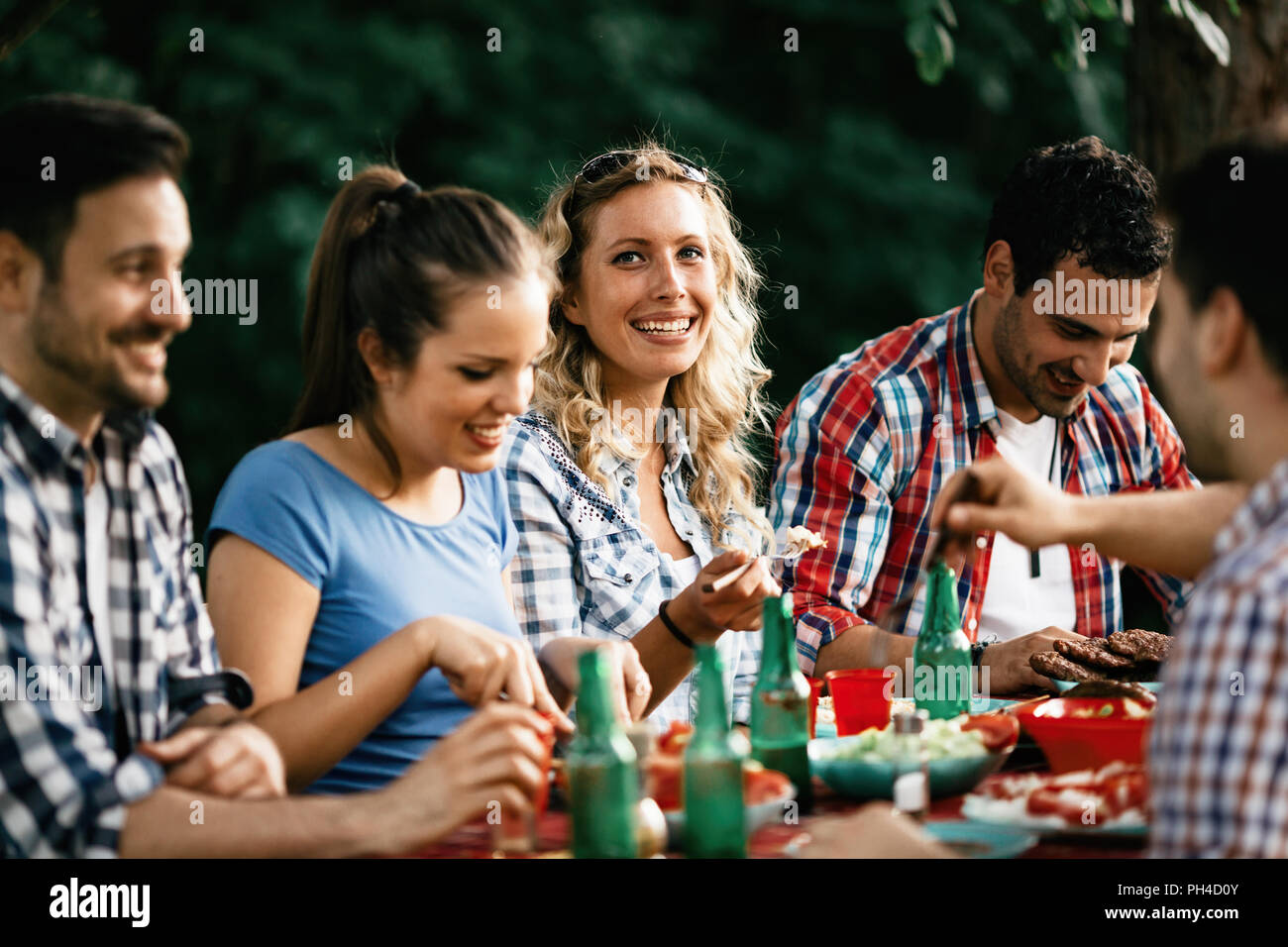Group of happy people eating food outdoors Stock Photo Alamy
