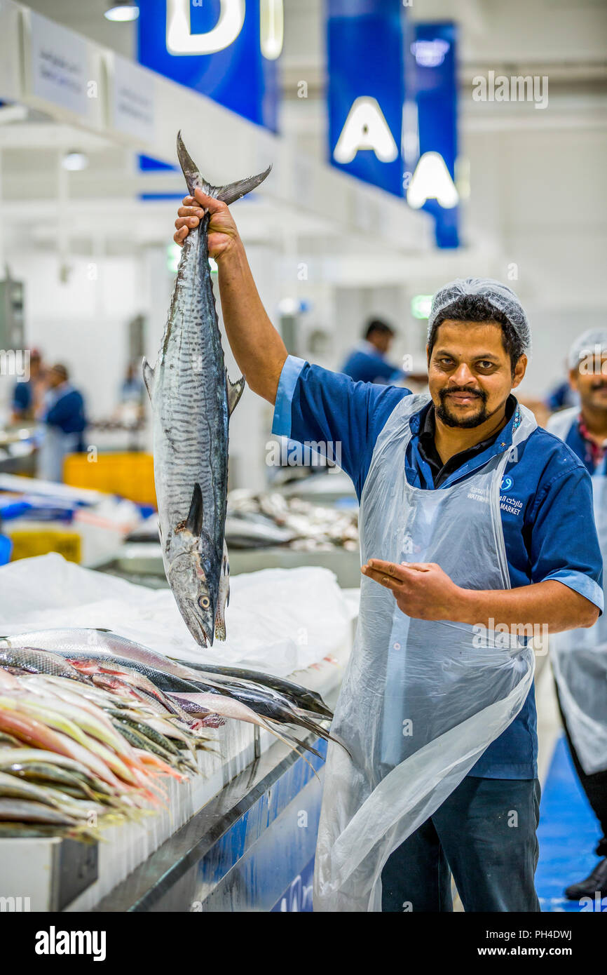Sales man holding Fresh raw barracuda fish in market Stock Photo