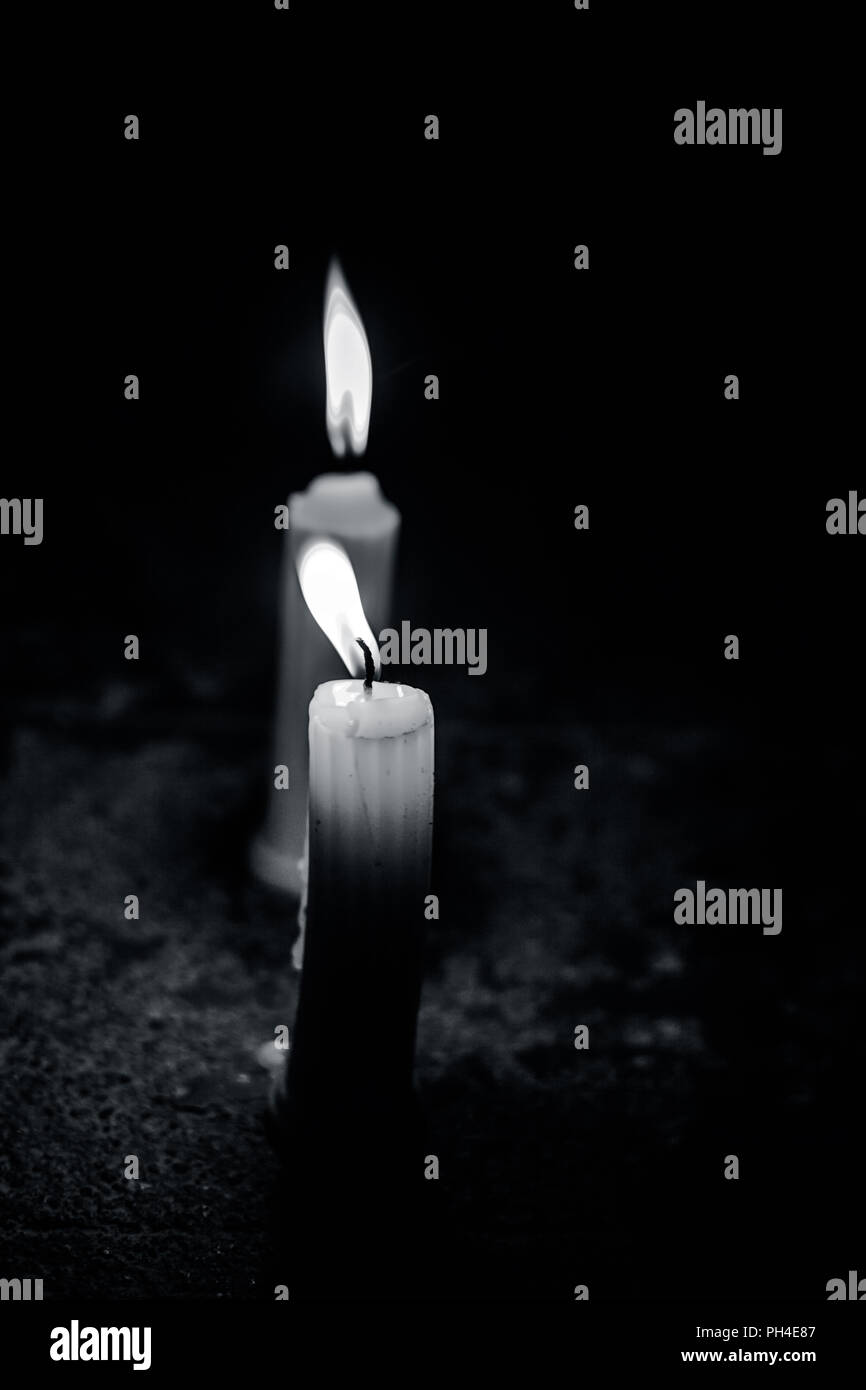 Single wax burning candle with a dark black background Stock Photo Alamy