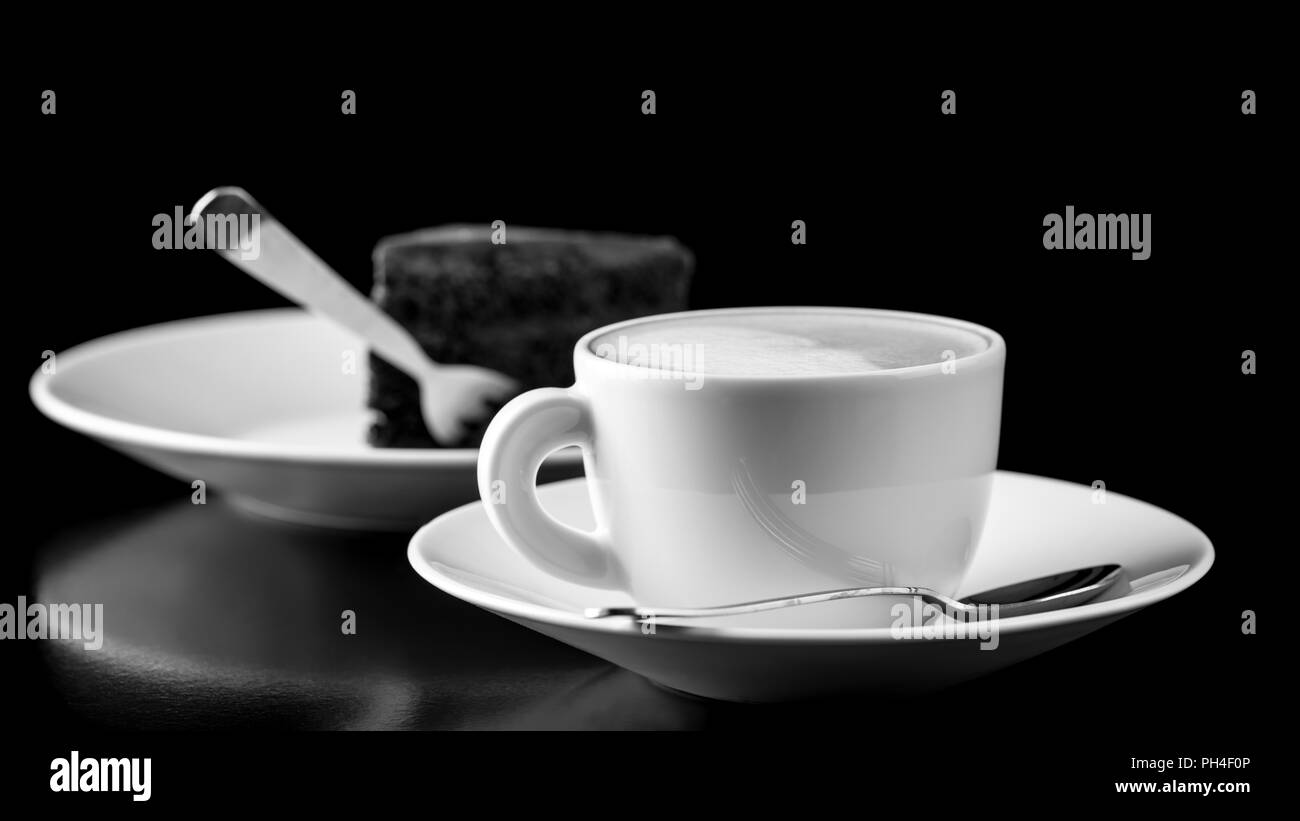 Black and white image of elegantly served chocolate cake and cappuccino. Stock Photo