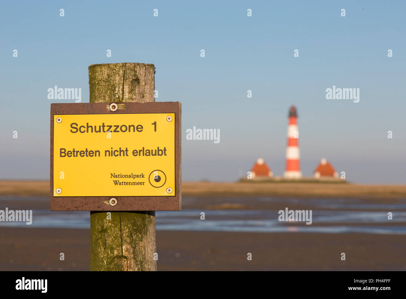 Sign indicating Protection Area 1 in front of lighthouse Westerheversand in salt marshes. Peninsula of Eiderstedt, North Frisia, Germany Stock Photo
