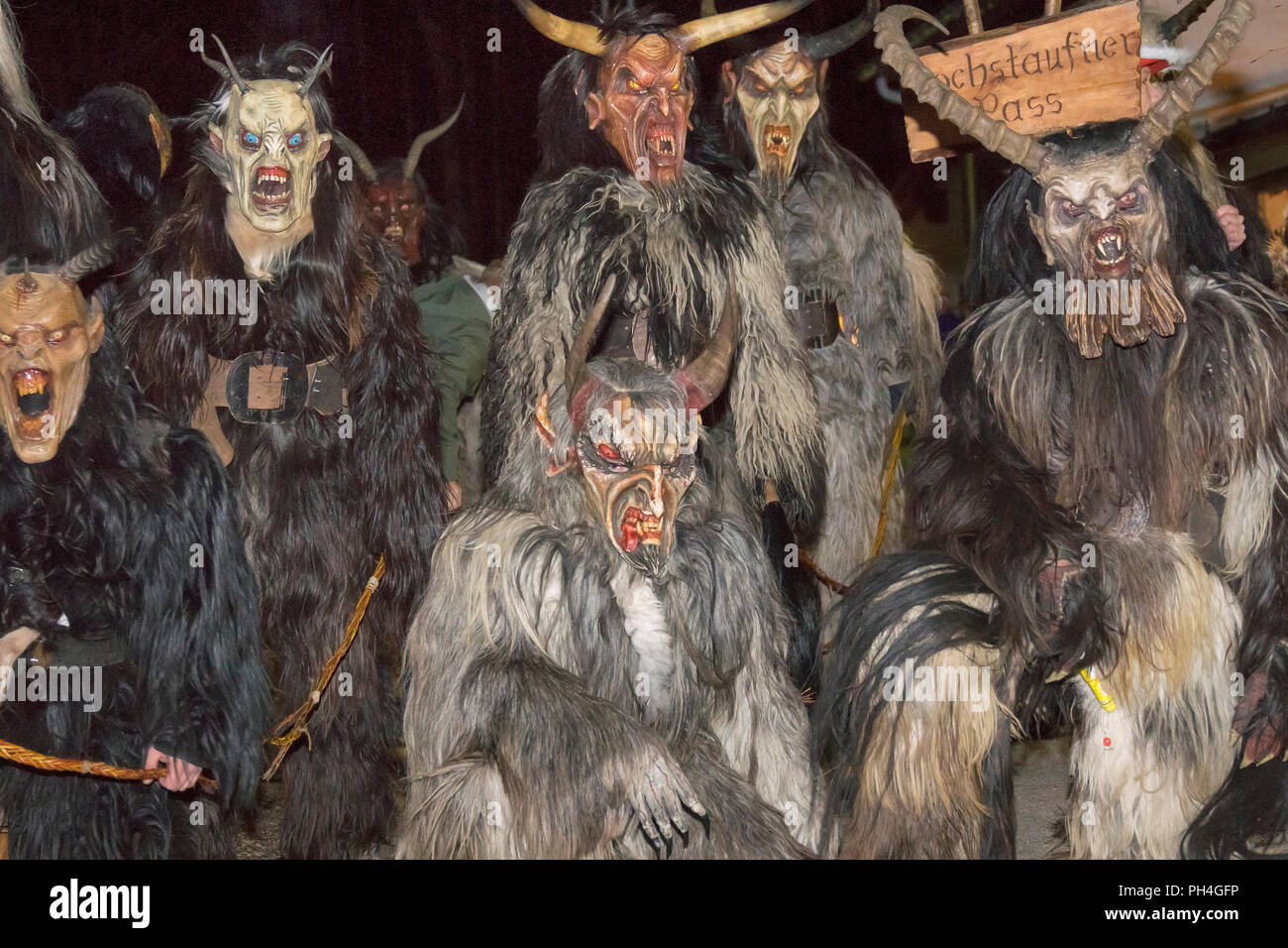 Group of man dressed as Perchten, mythical horned figures accompanying Saint Nicholas, gives warnings and punishments to the bad children. Bavaria, Germany Stock Photo