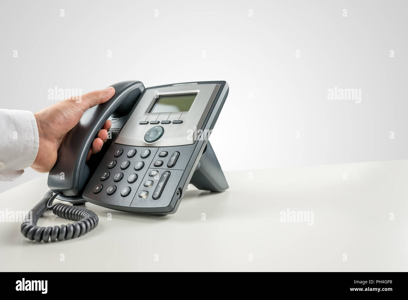 Closeup of businessman making a phone call on landline telephone
