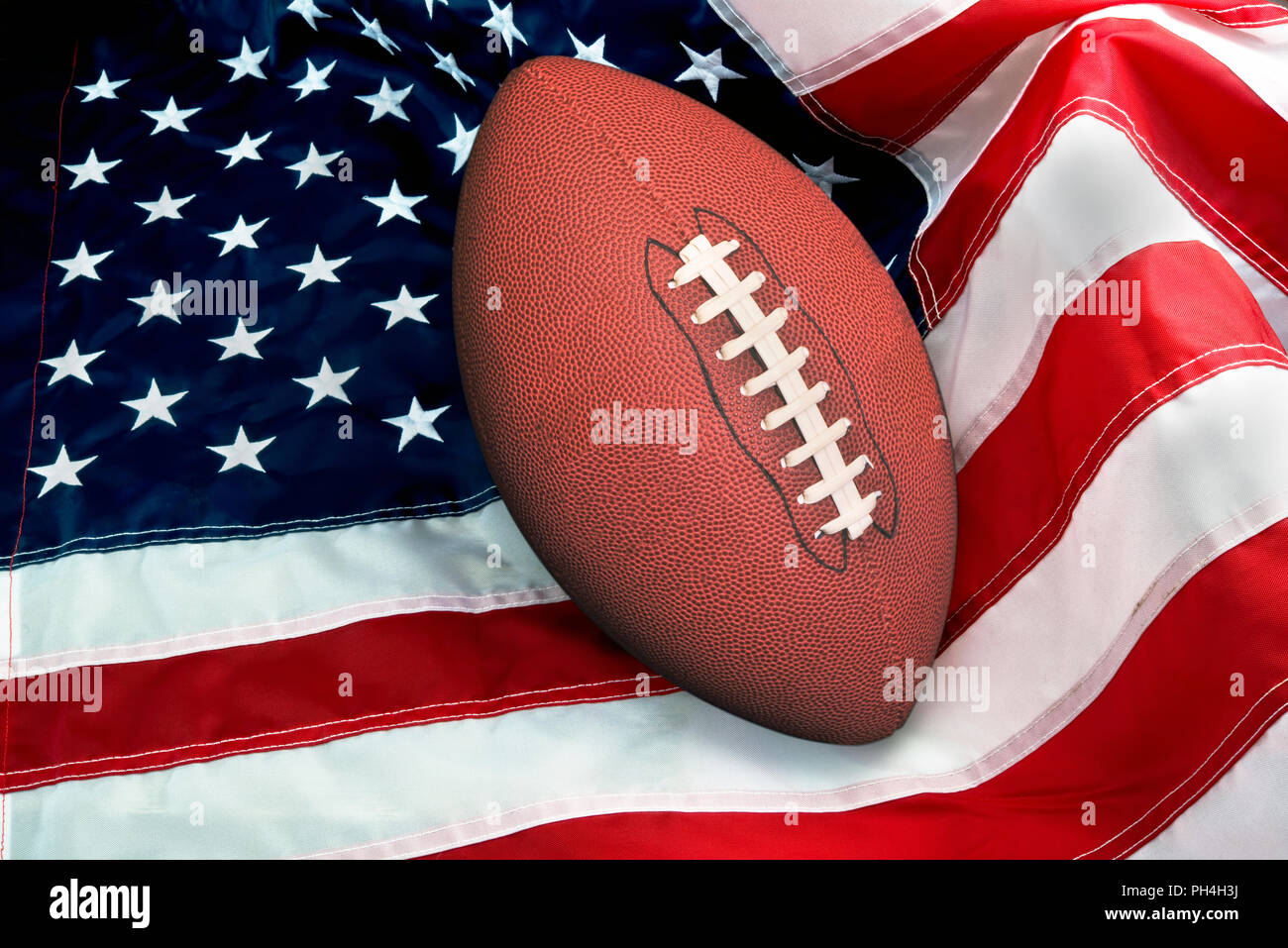 American football on American flag, old glory. Stock Photo