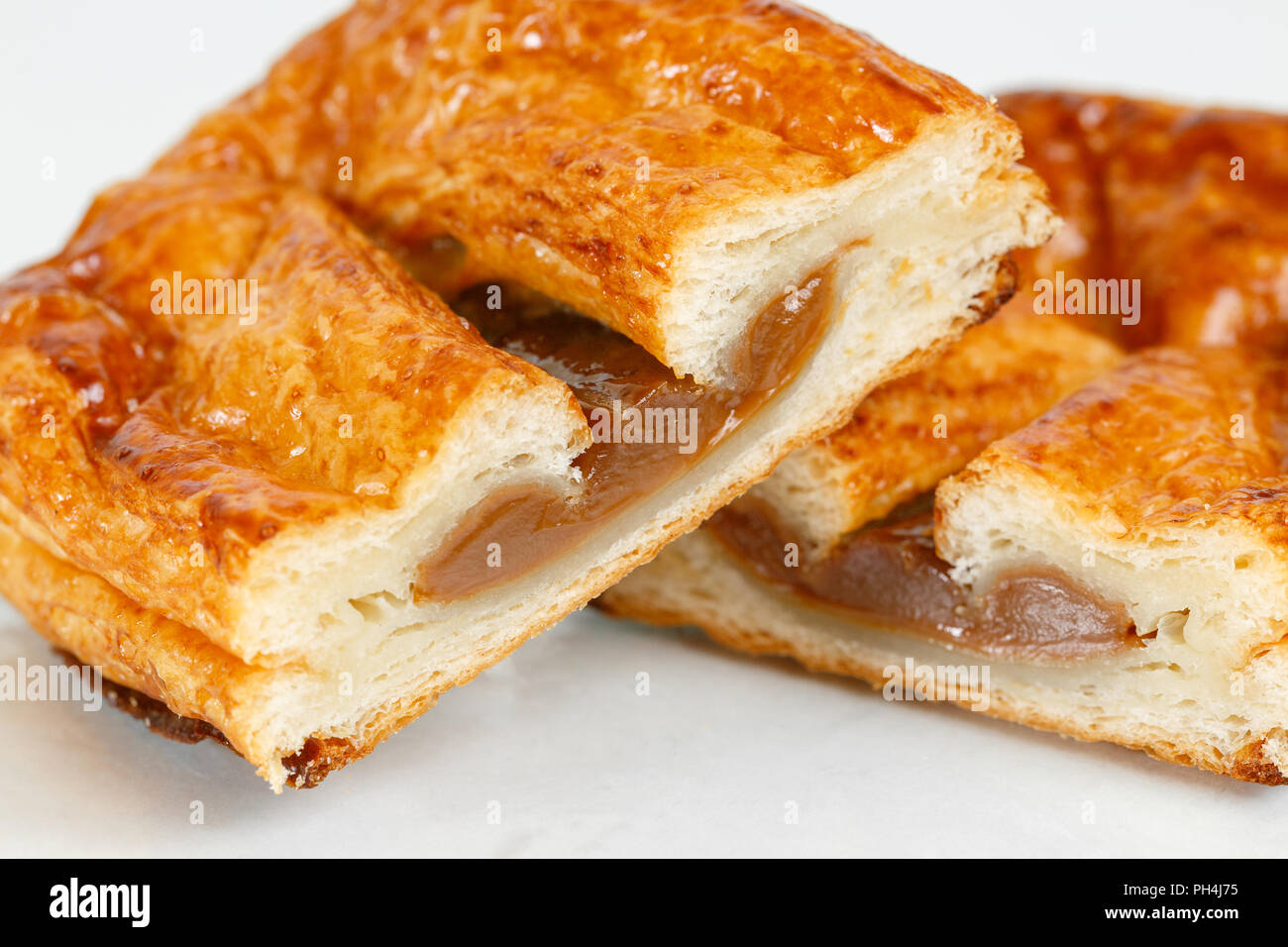 Tasty puff pastry dessert cut in half . Delicious pastries with fruit jam  on light background. condensed milk Stock Photo - Alamy