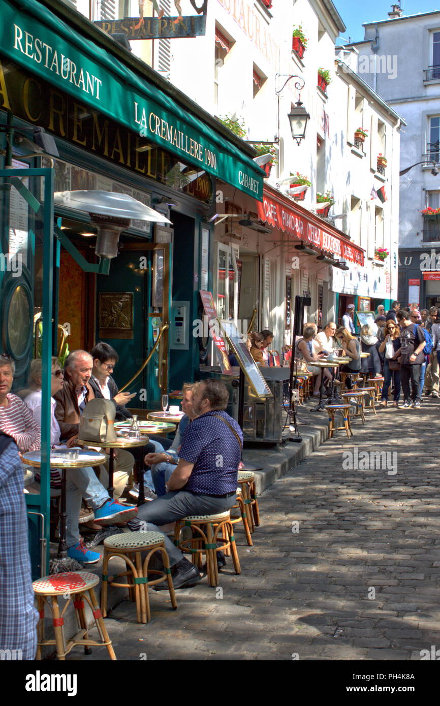 Paris, France - May 2, 2015: Typical urban scene of a cozy street with tables of cafe in the Montmartre district Stock Photo