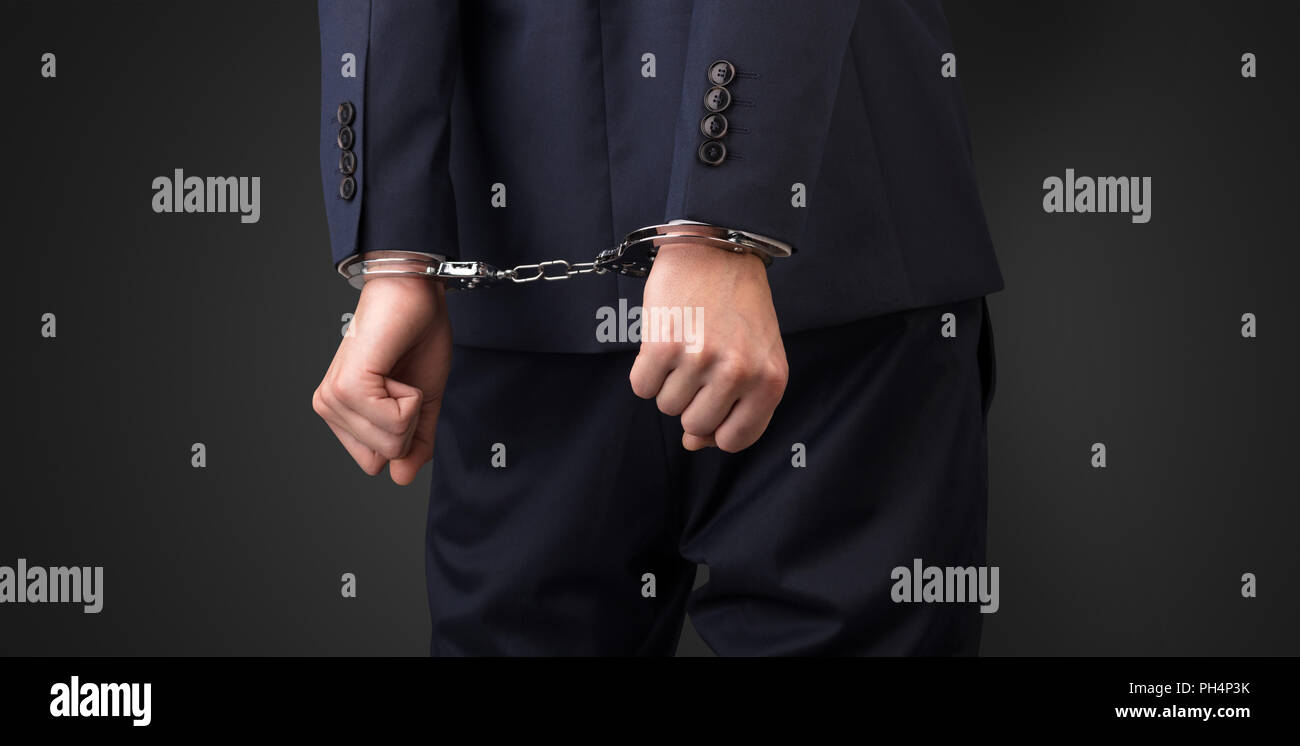 Close now arrested men hand with dark background and handcuffs  Stock Photo