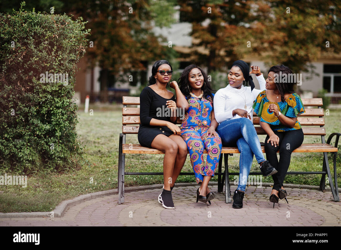 Four girls sitting on the bench hi-res stock photography and images - Alamy