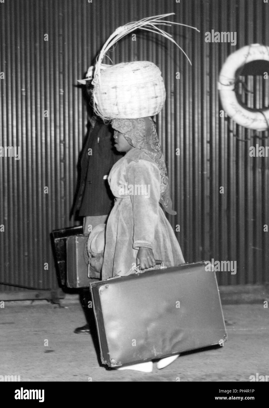 Jamaican woman, who is carrying part of her luggage on her head, is one of 151 women and 330 men who arrived at Southampton aboard the Holland-America line ship Sibajak to seek work in Britain. Stock Photo