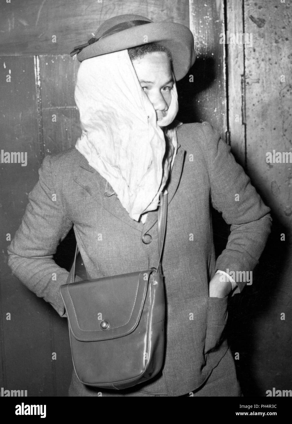 A West Indian immigrant tries to keep warm at London's Victoria Station. She is part of a party of West Indian immigrants who are searching to better their lives. *Scanned from contact. Neg corrupt Stock Photo