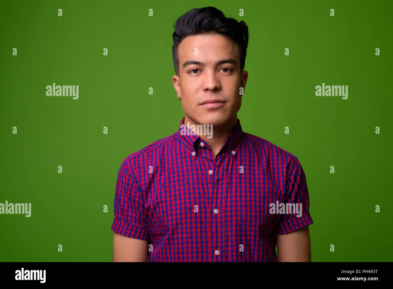 Young Multi Ethnic Man Wearing Purple Shirt Against Green